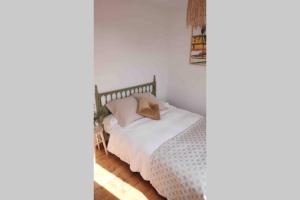 a bedroom with a bed with white sheets at El Escondite Inglés in Pantón