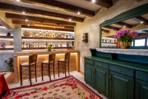 un bar con armarios verdes y taburetes en La Noi Guesthouse, en Samarína