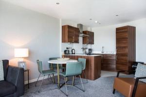eine Küche und ein Wohnzimmer mit einem Tisch und Stühlen in der Unterkunft Titanic & City Views, Ultra Luxury City Parking in Belfast