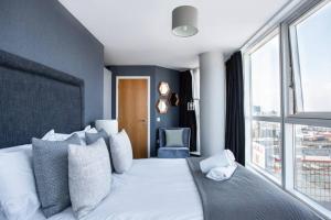 Schlafzimmer mit einem weißen Bett und einem großen Fenster in der Unterkunft Titanic & City Views, Ultra Luxury City Parking in Belfast