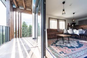 un soggiorno con divano e tavolo di Chalet Kristall - Dolomites Garden Chalet a Falzes