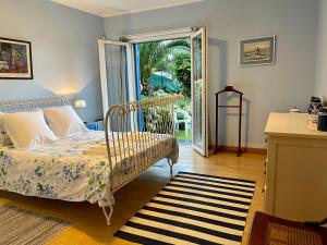 een slaapkamer met een bed en een glazen schuifdeur bij Casa Varanda do Mar in Capelas