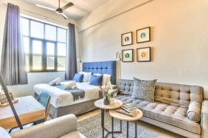 a living room with a bed and a couch at Oasis in the East City at The Harri in Cape Town