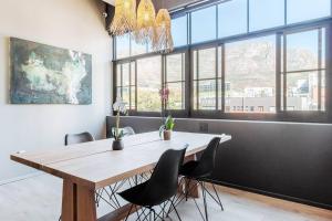 a dining room with a wooden table and chairs at Oasis in the East City at The Harri in Cape Town