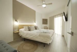 a bedroom with a large bed and a window at Tita Suite in Corralejo
