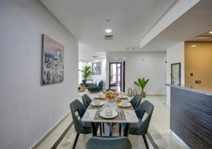 a dining room and living room with a table and chairs at bnbmehomes - Designer 3B - Sea Views - Dubai Marina in Dubai