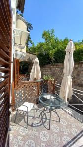 patio con tavolo in vetro, sedie e ombrellone di La Magnolia Sorrento - City Centre Hotel a Sorrento