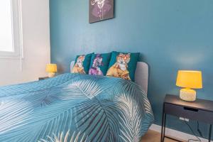une chambre bleue avec un lit et une table avec des lampes dans l'établissement Le Beau Coin - Thionville / Metz / Luxembourg, à Thionville