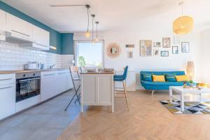 a kitchen and living room with a blue couch at Le Beau Coin - Thionville / Metz / Luxembourg in Thionville +19 photos