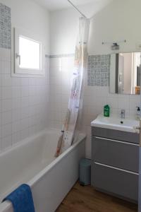 Baño blanco con bañera y lavamanos en FONTANES, en Niort