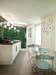 a kitchen with a table and chairs and green tiles at Residenza Borgo 27 in Grezzana