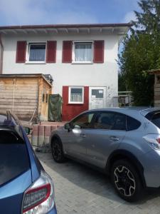 twee auto's geparkeerd voor een huis bij Oh-Apartment Lindenberg in Lindenberg im Allgäu