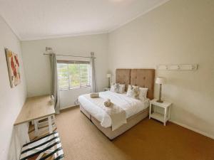 a bedroom with a large bed and a window at Leisure Isle Holiday Home in Knysna