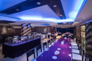 a restaurant with purple tables and chairs and a bar at Prime Park Hotel in Cox's Bazar