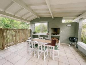 a patio with a table and chairs and a kitchen at Leisure Isle Holiday Home in Knysna