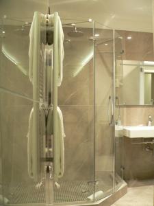 ein Badezimmer mit Dusche, an dem weiße Handtücher hängen in der Unterkunft Hotel Soperga in Mailand