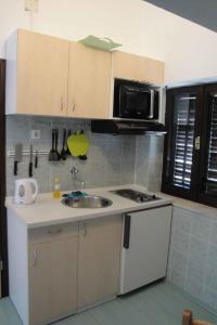 a kitchen with a sink and a microwave at Apartments Marica in Trogir