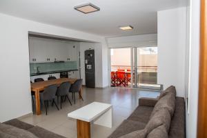 a living room with a couch and a table at 5 Sterne Apollo City Apartment in Lavrio