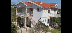 duży biały dom z balkonem i schodami w obiekcie Apartments Galic w Nin