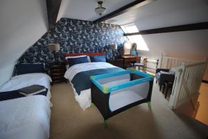 a bedroom with two beds and a blue and white wall at The Old Schoolhouse in Whitstable