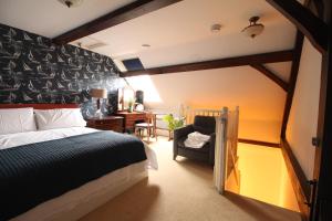 a bedroom with a bed and a chair and a desk at The Old Schoolhouse in Whitstable