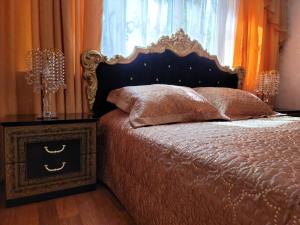 a bedroom with a bed and a nightstand next to a window at Apartment on Lenina Street in Chornomorsk