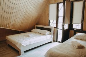 duas camas num quarto com duas janelas em Dom Adonis em Dilijan