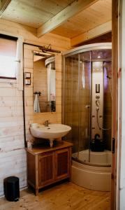 La salle de bains est pourvue d'un lavabo et d'une douche. dans l'établissement KORCAL faházak, à Koroncó