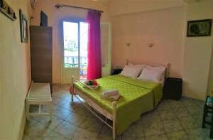 Un dormitorio con una cama verde y una ventana en Elli Rooms en Patitiri