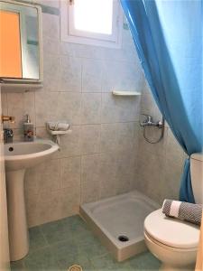 een badkamer met een wastafel, een toilet en een bad bij Elli Rooms in Patitiri