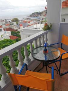 a table and chairs on a balcony with a view of the ocean at Elli Rooms in Patitiri