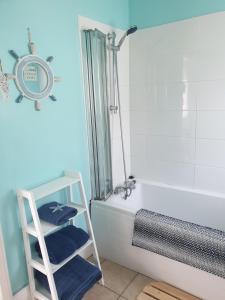 a bathroom with a ladder next to a bath tub at Cosy seaside apartment in Woodhorn