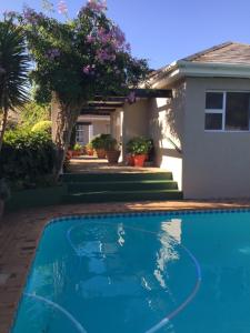 a swimming pool in front of a house at Brown Jug Guest House in Hermanus