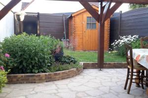 a patio with a table and chairs and a fence at Agréable logement dans petit village sud-essonne in Champcueil