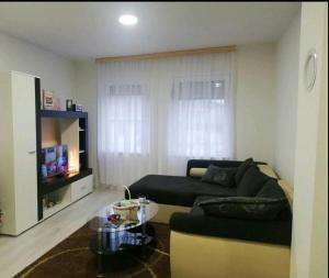 ein Wohnzimmer mit einem Sofa und einem Tisch in der Unterkunft Apartman Centar Novi Grad in Bosanski Novi