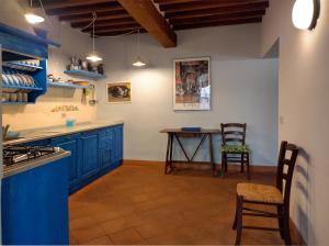 ガイオーレ・イン・キアンティにあるCasanova di Ricavoのキッチン(青いキャビネット、テーブル、椅子付)