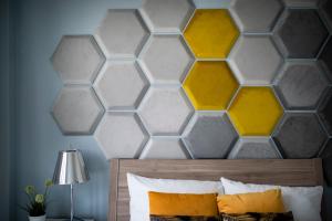 um quarto com uma cabeceira hexagonal com amarelo e cinzento em EASY RENT Apartments - SKY em Lublin