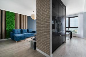 een woonkamer met een blauwe bank en een bakstenen muur bij EASY RENT Apartments - SKY in Lublin