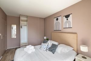 een slaapkamer met een bed met witte lakens en kussens bij Ty Marie by Cocoonr in Rennes