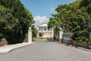 a white house with a gate and a driveway at Villa Elena in Perea