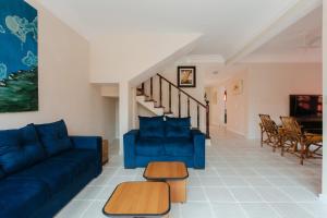 a living room with blue couches and a staircase at CASAPERNAMBUCO 100mts da praia in Guarujá
