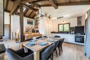 Chalet Jatoba Chamonix - by EMERALD STAY في شامونيه مون بلان: مطبخ وغرفة طعام مع طاولة وكراسي خشبية