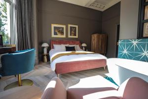 a bedroom with a bed and a blue chair at Boutique 50 in Glasgow