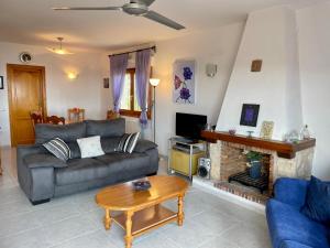 a living room with a couch and a fireplace at Villa Patricia in Benitachell