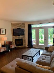 uma sala de estar com um sofá e uma lareira em Condo Le Champlain-102 em Bromont