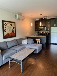 sala de estar con sofá y cocina en Condo Le Champlain-102, en Bromont