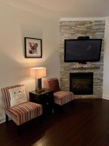 a living room with two chairs and a fireplace at Condo Le Champlain-102 in Bromont