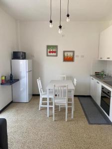 a kitchen with a white table and a white refrigerator at Il fuso di Maria in Borghetto di Vara
