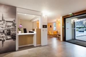 a hallway with a kitchen and a living room at Comfort Hotel Amiens Nord in Amiens