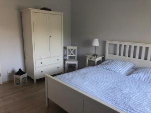um quarto com uma cama e um armário branco em Apartment Am Gondelteich em Bad Elster